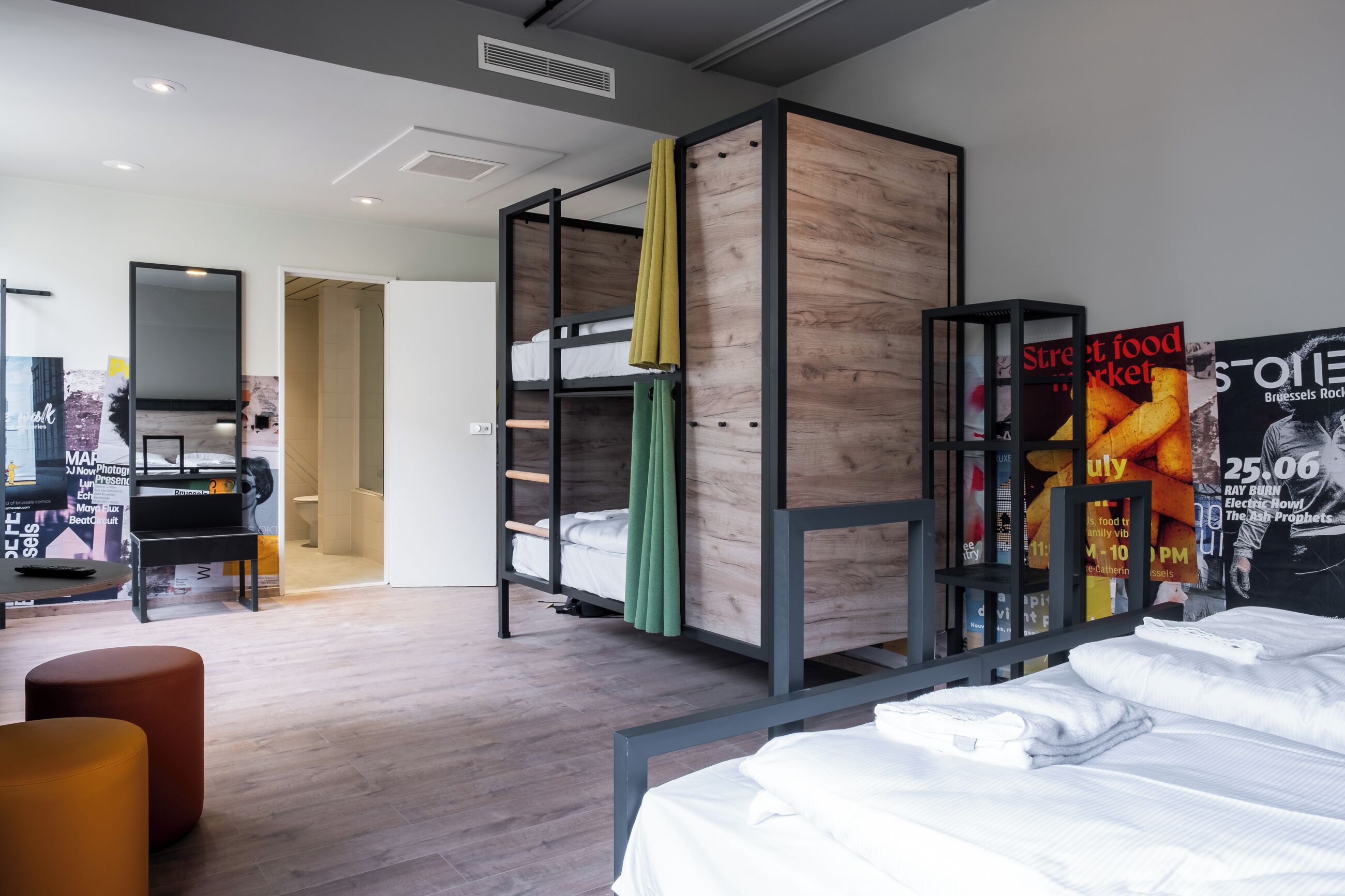 Ein modernes Hotelzimmer mit Etagenbett, Schreibtisch und Klavier.