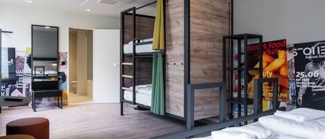 Una habitación de hotel moderna con una cama nido, un escritorio y un piano.