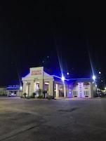 Un edificio con un letrero que dice 'BEST PRICE HOTEL & SUITES' de noche.