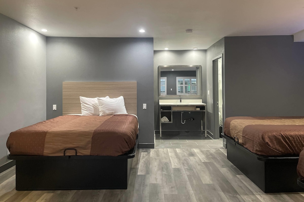 Une chambre d’hôtel avec deux lits, une salle de bain et une petite kitchenette.