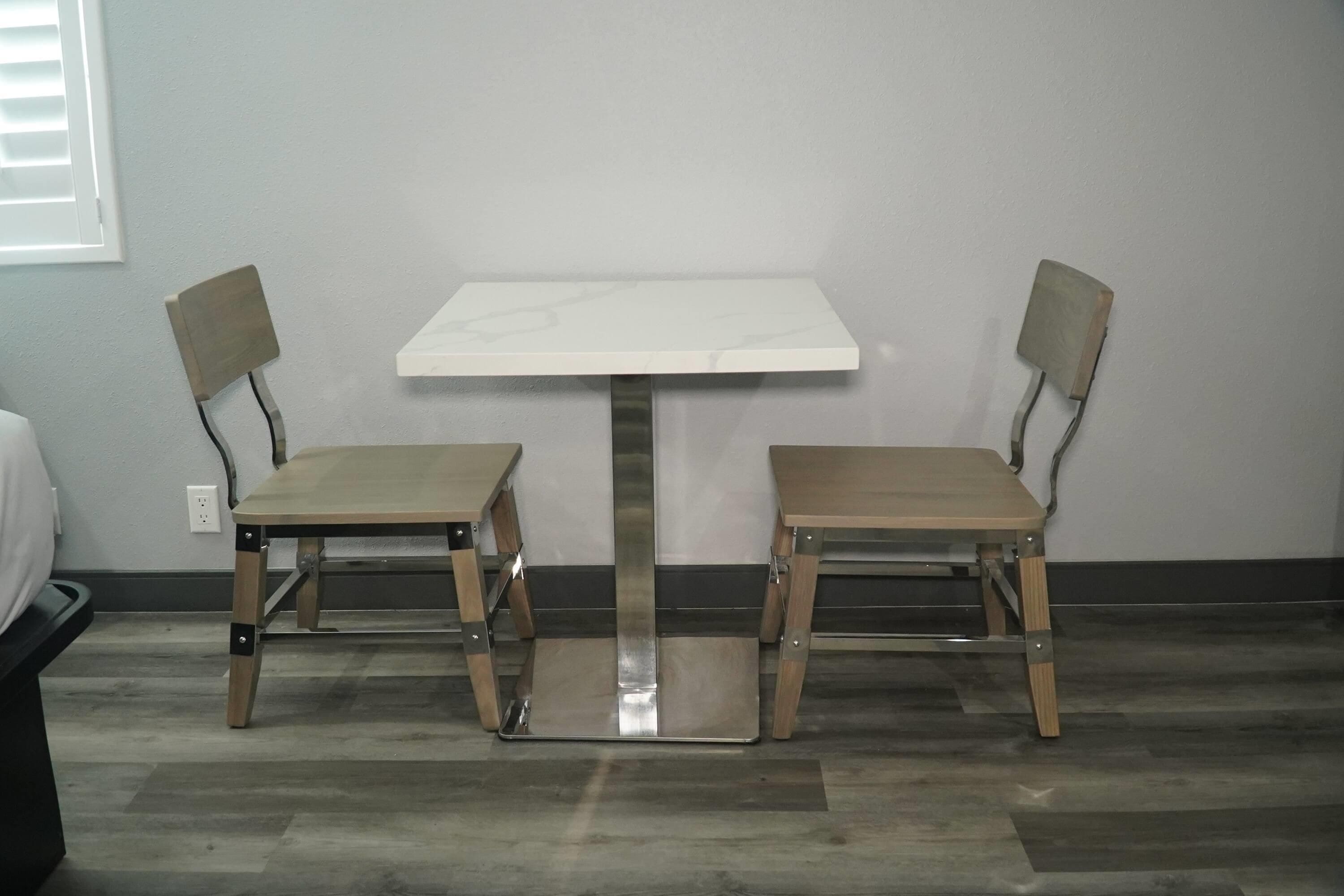 Una habitación pequeña con una mesa blanca y dos sillas.