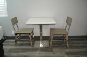 Una habitación pequeña con una mesa blanca y dos sillas.