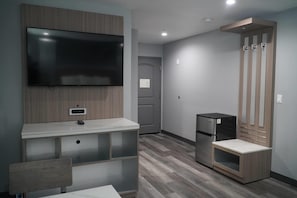 A modern kitchen with a built-in TV, a refrigerator, and a wooden cabinet.
