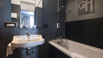 Ein modernes Badezimmer mit Waschbecken, Badewanne und großem Spiegel.