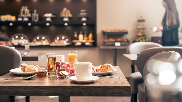 A breakfast table with pastries, a cup of coffee, and a glass of orange juice. - Le Grand Hotel By Stay Collection (Strasbourg)