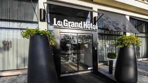 The entrance to Lo Grand Hotel with large black planters and a modern facade. - Le Grand Hotel By Stay Collection (Strasbourg)