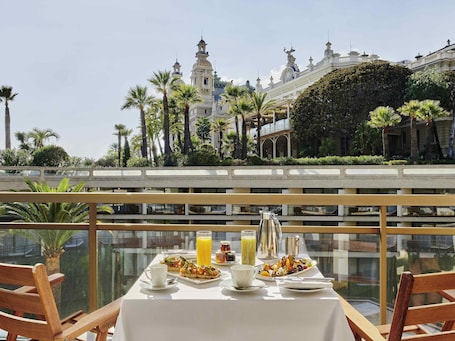 A dining table with breakfast items and a view of a historic building.. Fairmont Monte Carlo