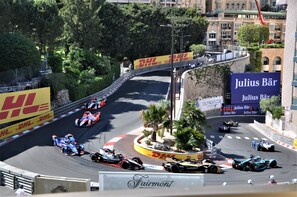 A race track with multiple racing cars and a DHL advertisement.