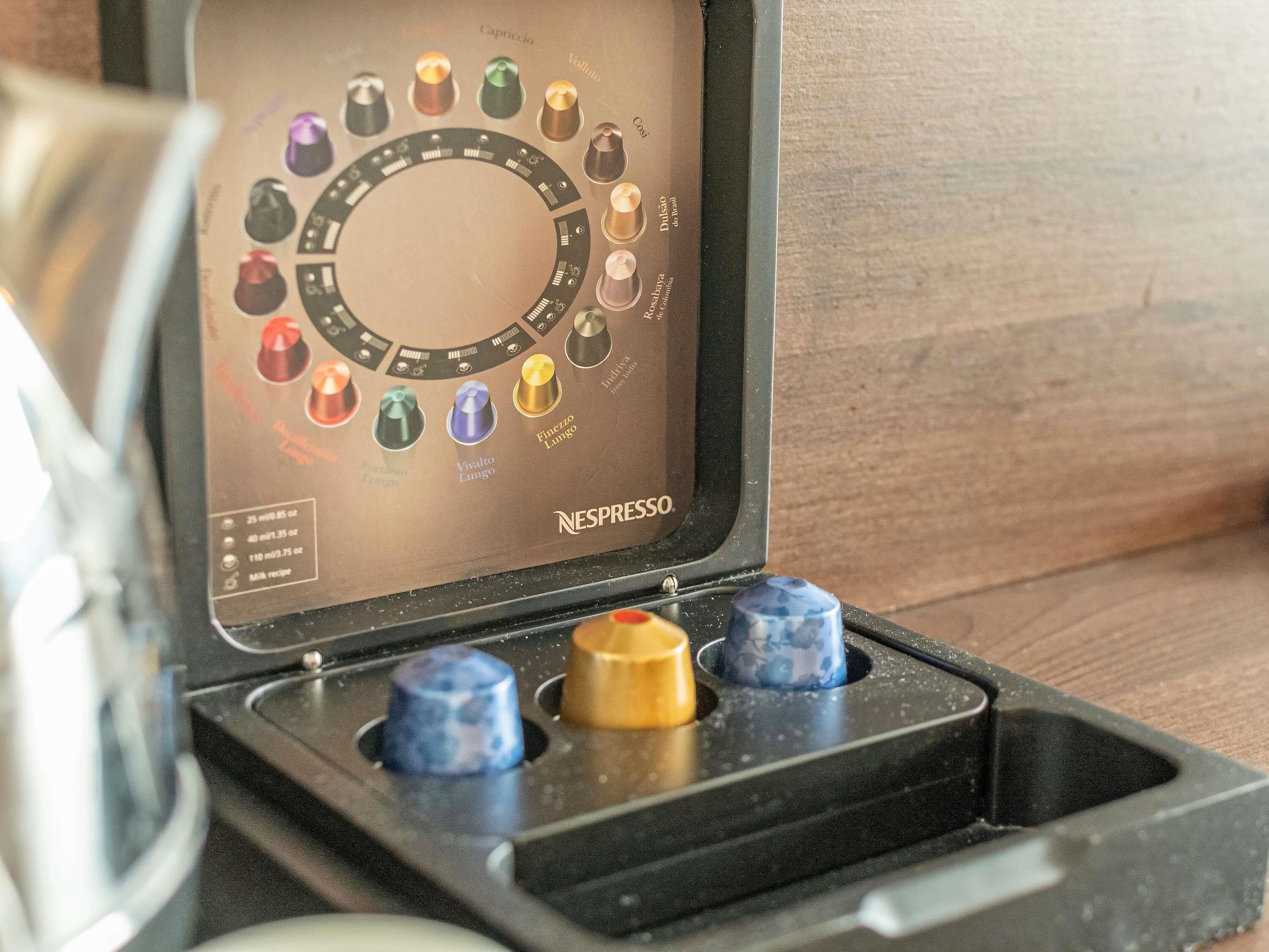 A coffee machine with a selection of coffee pods in a case.