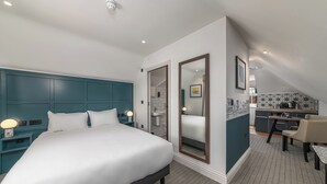 A modern hotel room with a large bed, a desk, and a kitchenette. - Mercure White Hart Hotel Salisbury and Apartments (Salisbury)