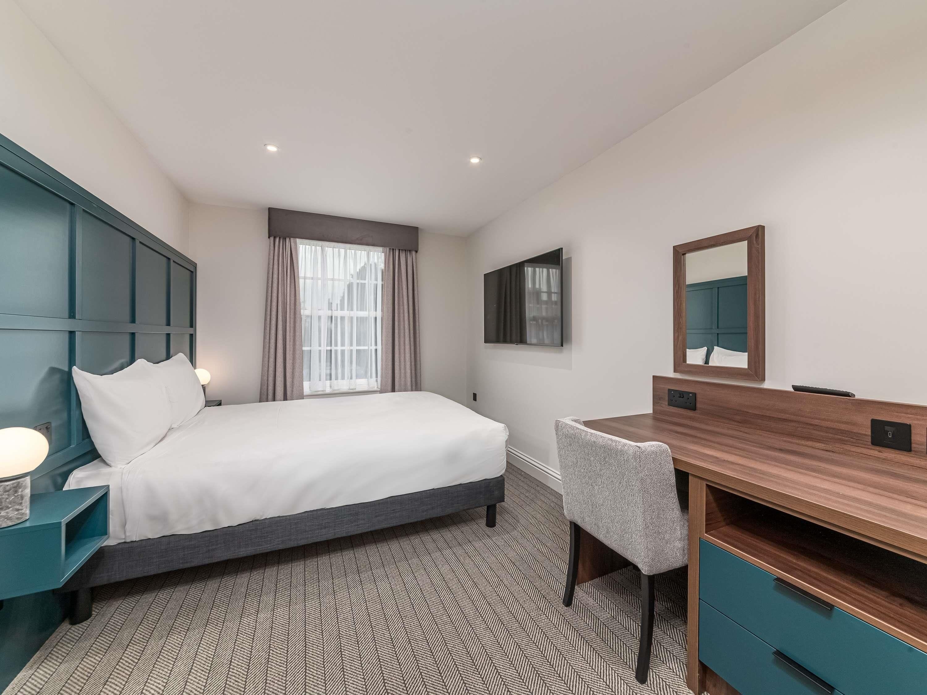 Premium bedding, desk, laptop workspace, blackout drapes