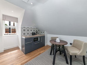 A compact kitchen with a modern design, including a built-in microwave and a coffee maker. - Mercure White Hart Hotel Salisbury and Apartments (Salisbury)