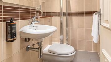 Un baño con lavamanos blanco, inodoro y ducha.