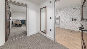 A modern hotel room with a large mirror, a wooden floor, and a tiled wall. - Mercure White Hart Hotel Salisbury and Apartments (Salisbury)