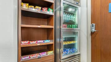 Máquina expendedora con aperitivos y bebidas, incluyendo papas Lay's y Coca-Cola.