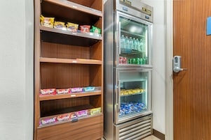 Máquina expendedora con aperitivos y bebidas, incluyendo papas Lay's y Coca-Cola.