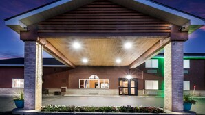 A building with a covered entrance, a central doorway, and a small seating area. - Quality Inn & Suites Steamboat Springs (Steamboat Springs)