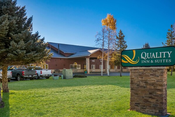 A Quality Inn & Suites sign in front of a building with a brick facade and a sloped roof. - Quality Inn & Suites Steamboat Springs (Steamboat Springs)