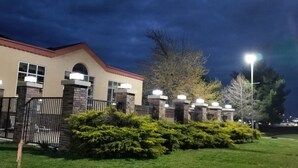 A building with a beige facade, stone pillars, and a red roof. - Quality Inn & Suites Carthage near Precious Moments Chapel (Carthage)