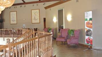 A spacious lobby with a wooden staircase, comfortable seating, and a large mirror.
