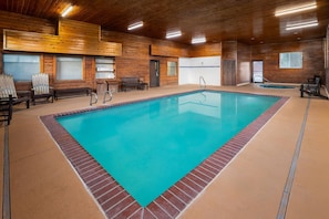 An indoor swimming pool with wooden walls and benches.