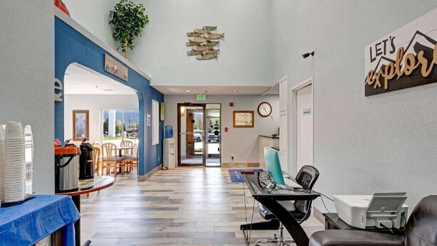 A reception area with a desk, chairs, a coffee station, and a view of the outdoors.