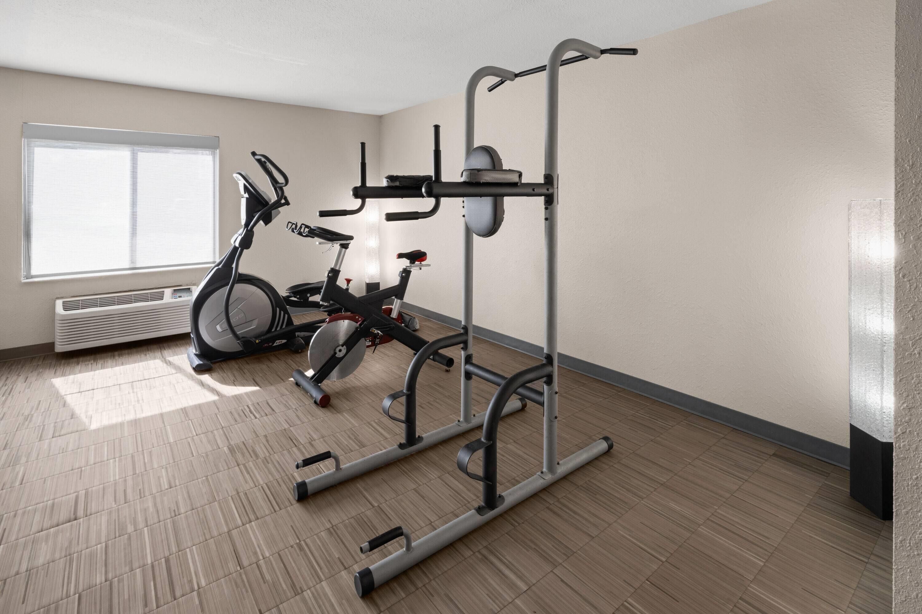 Un gimnasio con equipo de ejercicio, una ventana y un radiador.