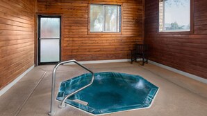 A wooden cabin with a glass-bottomed hot tub, a door, and a window.