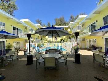 A poolside area with a person serving food to a child. at Magic Castle Hotel