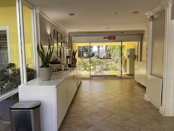A modern kitchen with white cabinets, a stainless steel refrigerator, a microwave, and a stove. at Magic Castle Hotel