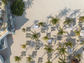 On the beach, white sand, beach cabanas, sun loungers