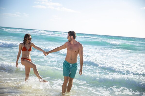 On the beach, white sand, beach cabanas, sun loungers