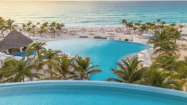 A resort pool with a view of the ocean and beach. - Le Blanc Spa Resort Cancun - Adults Only - All-Inclusive (Cancun)