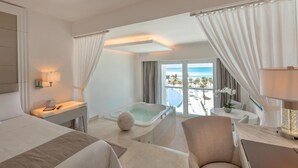 A hotel room with a bed, a desk, a laptop, a bathtub, and a view of the beach. - Le Blanc Spa Resort Cancun - Adults Only - All-Inclusive (Cancun)