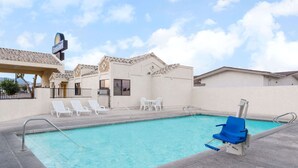A swimming pool with a lifeguard chair, lounge chairs, and a Days Inn sign. - Days Inn by Wyndham Kingman West (Kingman)
