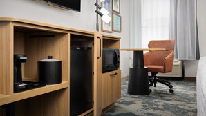 A compact hotel room with a kitchenette, a single bed, a chair, and a TV. - Hampton Inn Fayetteville Fort Bragg (Fayetteville)