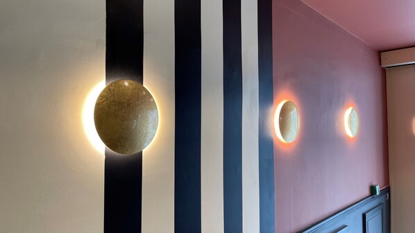 A wall with three round wall sconces emitting a warm glow.