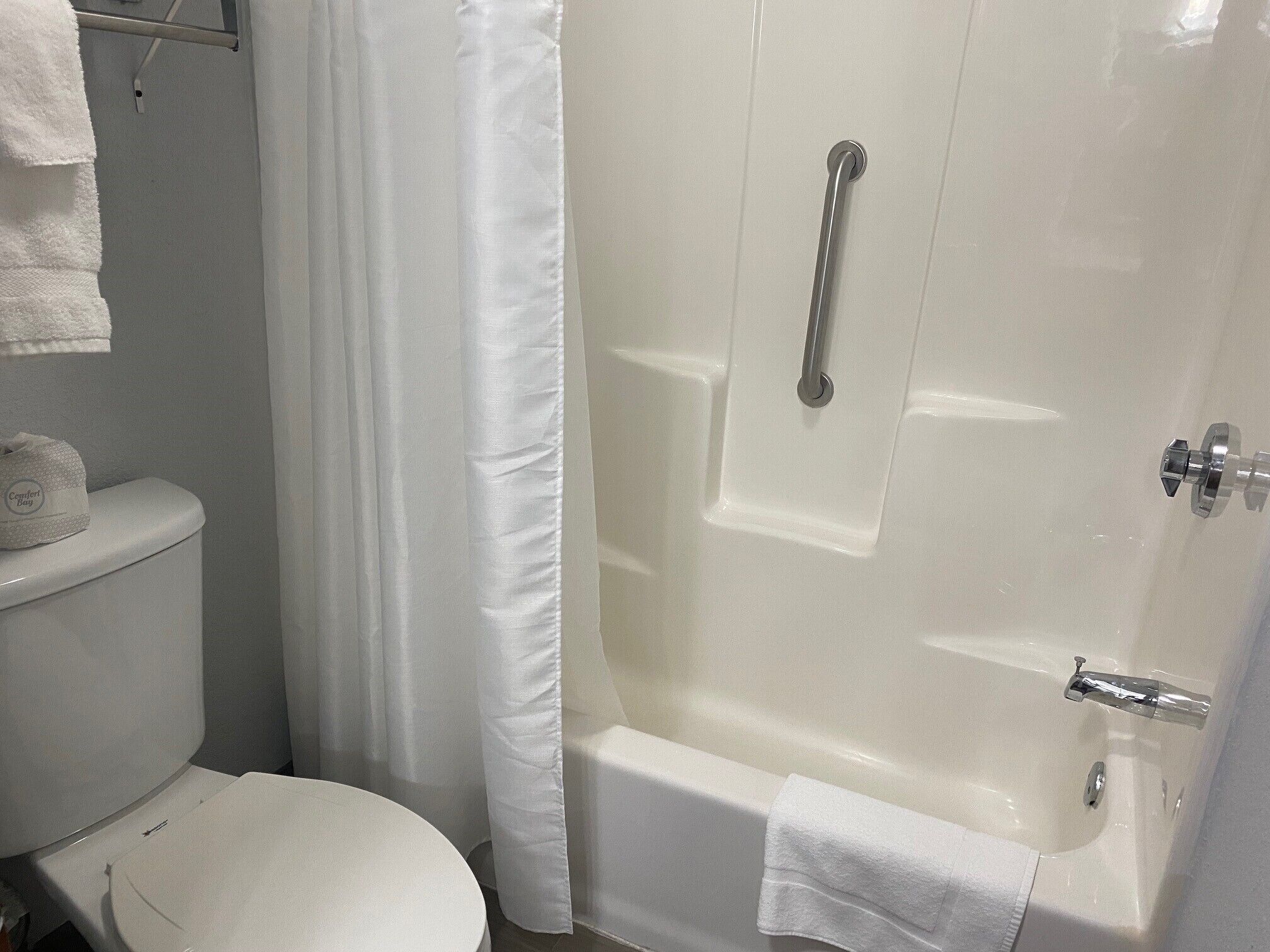 Un baño con inodoro, bañera y cortina de ducha.