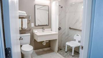 Een kleine badkamer met toilet, wastafel en douche.
