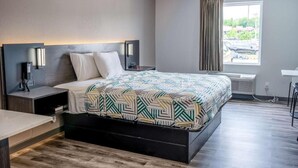 Une chambre d’hôtel moderne avec un grand lit, des tables de chevet, un bureau et une fenêtre avec des rideaux.