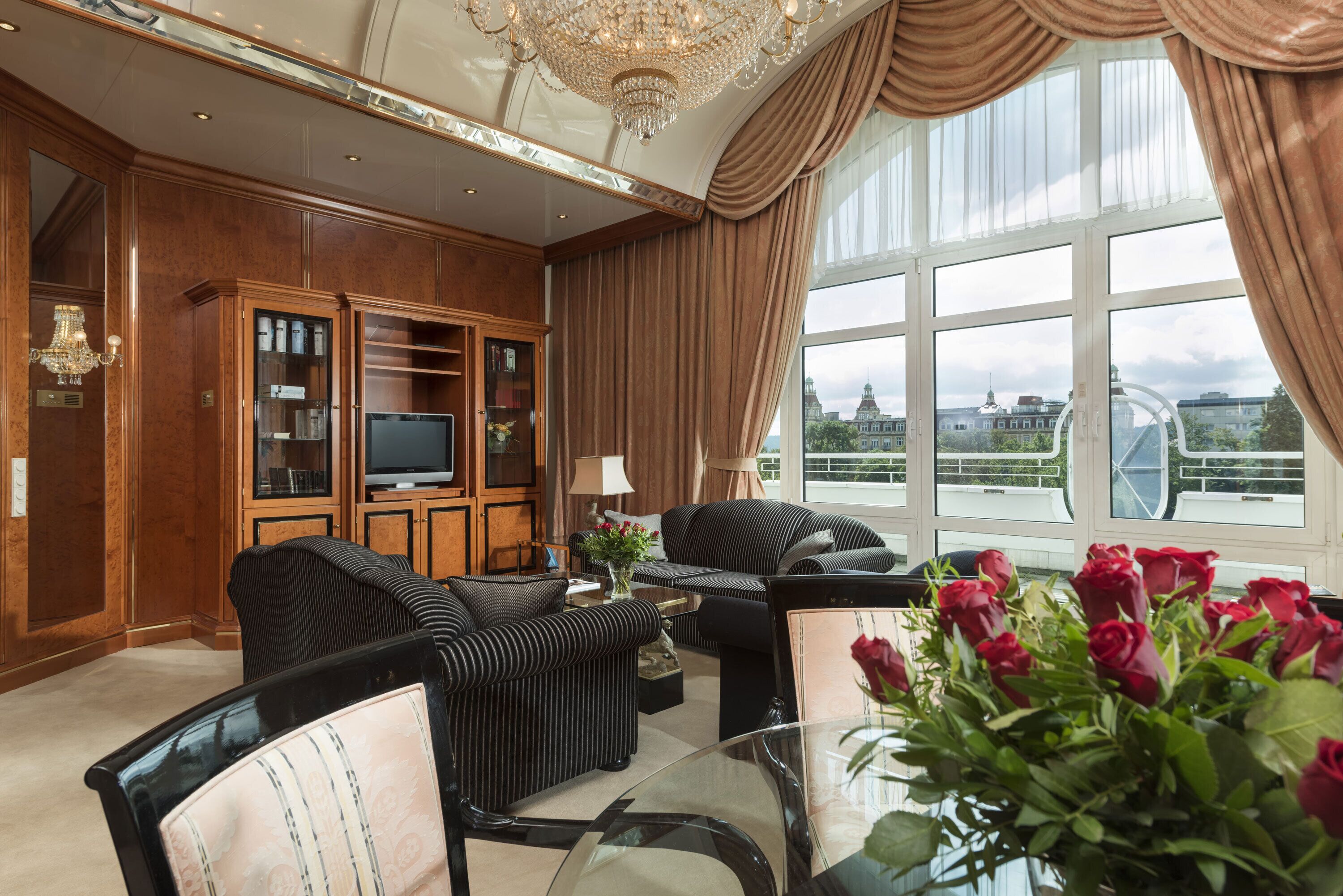 Un salón amplio con un gran ventanal, un televisor y un sofá.