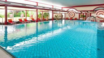Relax by the pool surrounded by a sleek, curved structure with a large window offering a view.