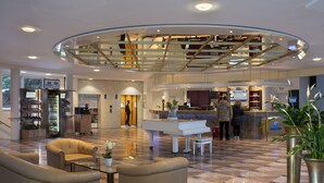 A hotel lobby with a grand piano, seating area, and a reception desk. - Maritim Hotel Bad Wildungen (Bad Wildungen)
