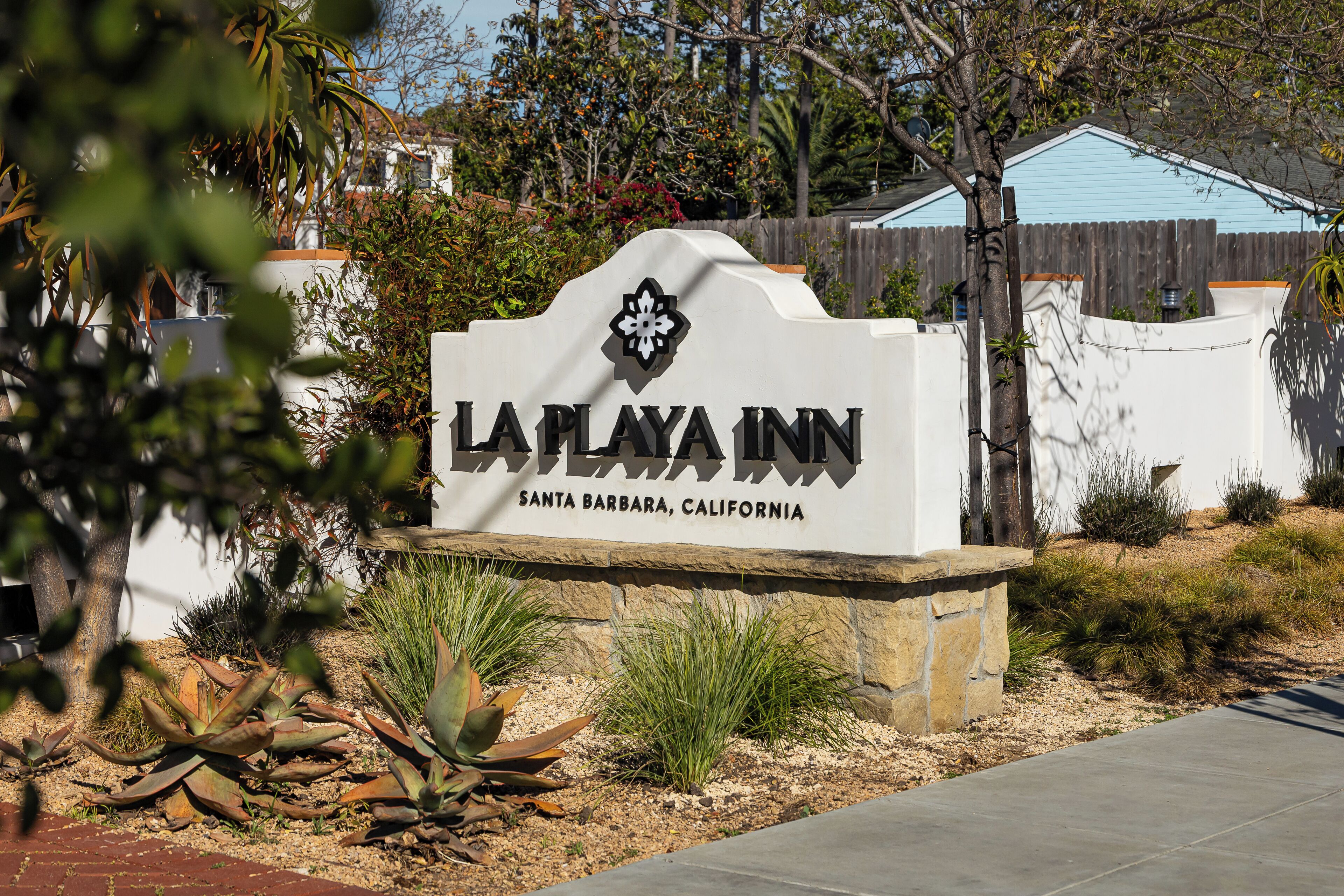 A sign for La Playa Inn in Santa Barbara, California, with a decorative top and a flower emblem.