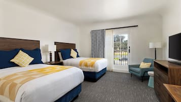 A hotel room with two beds, a TV, a chair, and a balcony with curtains.