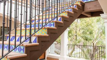 A spiral staircase with a geometric tile pattern on the steps and a metal railing.