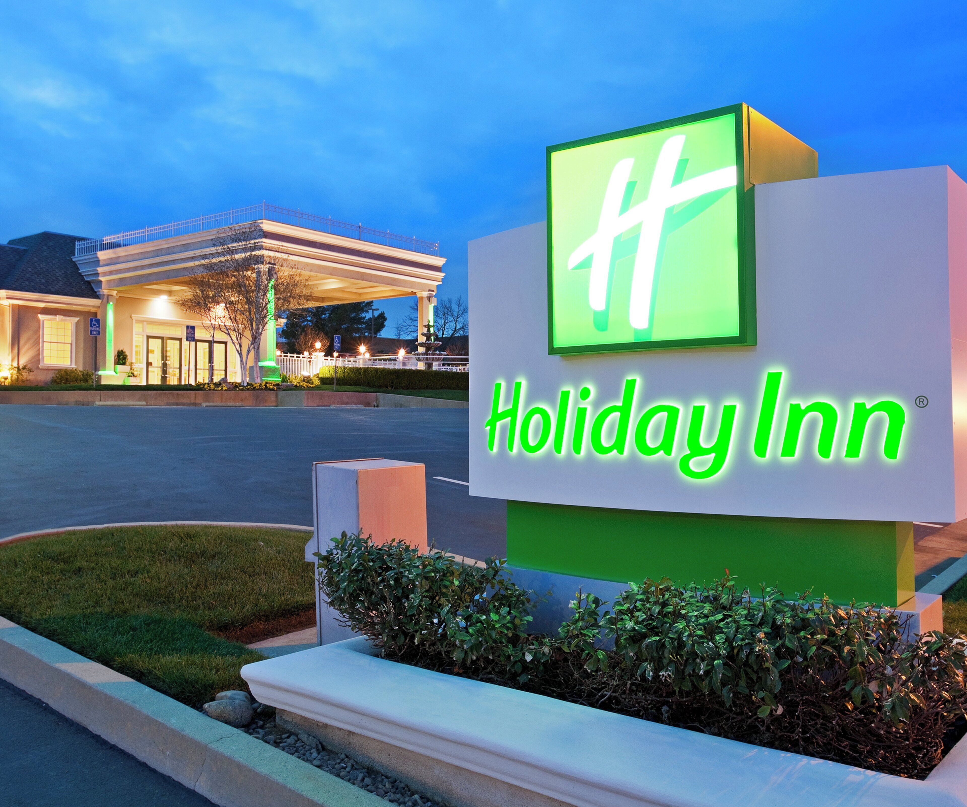 A Holiday Inn sign with a green logo and the name 'Holiday Inn' in white letters.