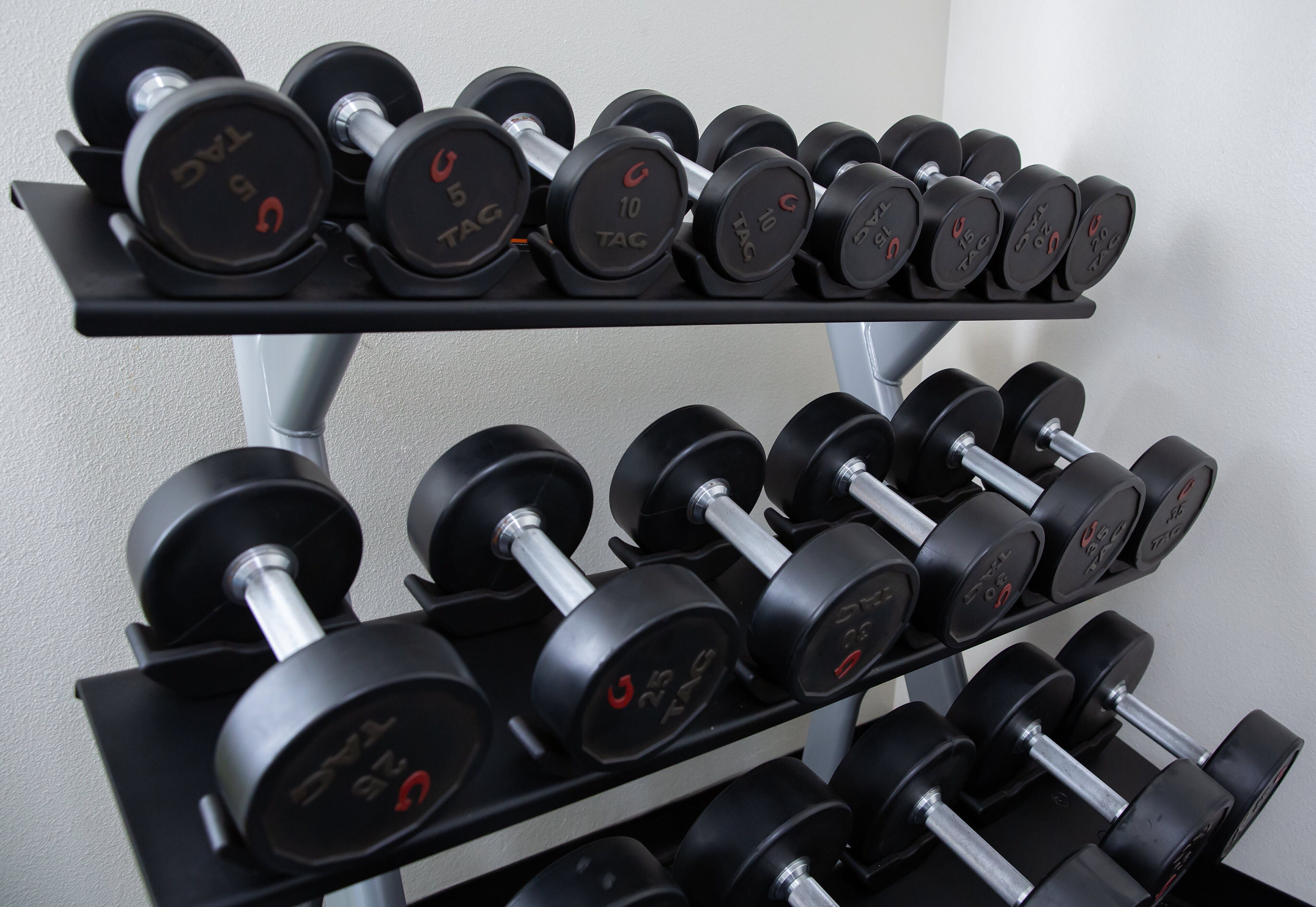 A rack of dumbbells with various weight markings.