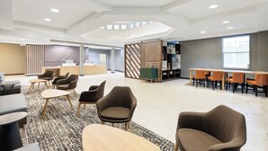 A spacious, modern lounge area with a reception desk, seating arrangements, and a bookshelf. - Holiday Inn Redding by IHG (Redding)