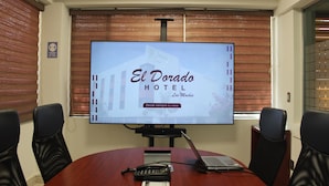 A conference room with a large screen displaying 'El Dorado Hotel Los Mochis' and a sign indicating a smoking area. - Hotel El Dorado (Los Mochis)